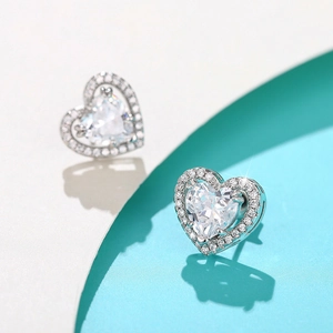 Detailed macro view of heart-shaped silver earrings with sparkling cubic zirconia inlay