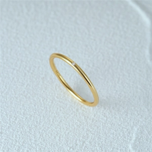 Close-up of minimalist gold slender ring featuring a sparkling zircon stone inlay