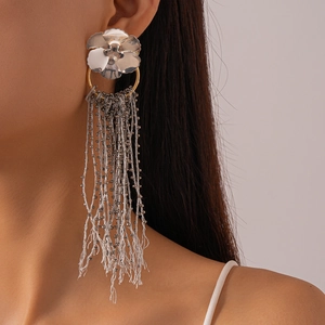 Macro shot of long flower earrings with dark gray glass bead tassels on model
