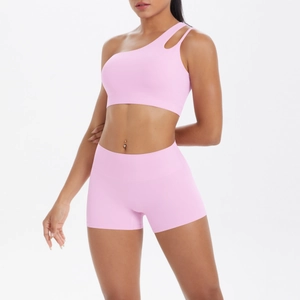 Detail of pink one-shoulder cutout sports bra and high-waist fitness shorts set for yoga