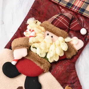 Detail of plush Santa Claus Christmas stocking with 3D figurines and festive patterns