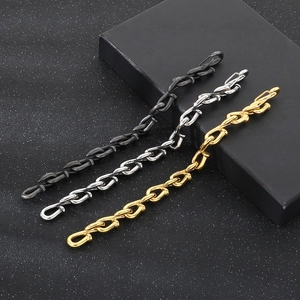 Detailed close-up of three-tone gold silver and black steel chain link bracelets for men