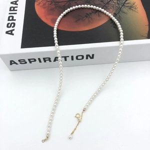 Detail of white pearl necklace with adjustable gold-plated clasp and extension chain