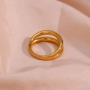Macro shot of double-layer gold plated stainless steel rings on pink silk background