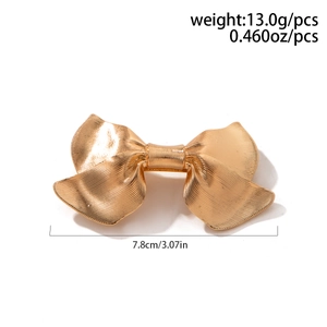 Detail view showing golden metal bow hair tie with textured finish and 7.8cm size
