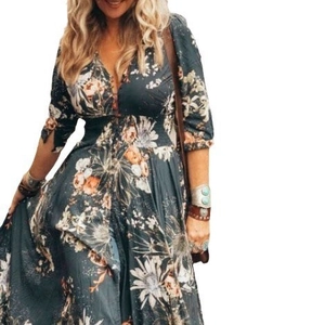 Détail d'une robe longue vert foncé avec imprimé floral, col en V et style bohème