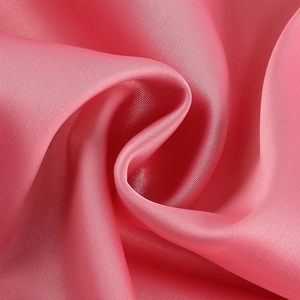 Gros plan détaillé du tissu satin rose montrant la texture lisse et les reflets