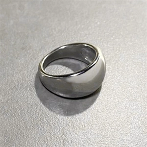 Détail macro d'une bague bombée en acier inoxydable argenté poli avec finition miroir