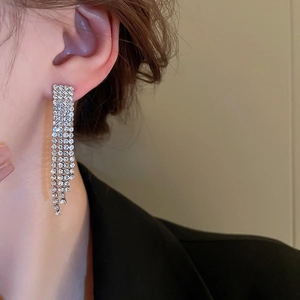 Orecchini a nappa d'argento con strass scintillanti indossati da una modella