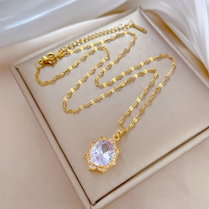 Close-up of gold necklace with oval white gemstone pendant on a luxury jewelry box