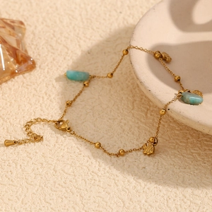 Detail of 18K gold-plated anklet with blue amazonite bead and fish-shaped pendant charm