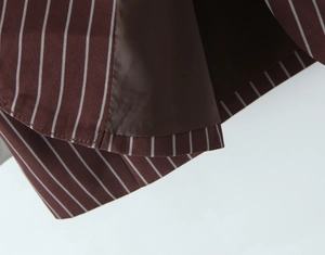Detail shot of brown striped blazer hem and lining with precise stitching and fabric texture
