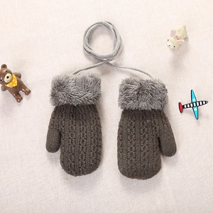 Detail of brown knitted toddler gloves with gray faux fur cuffs and a secure hanging neck cord