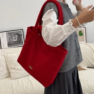 Dettaglio borsa shopper rossa in pile con etichetta in pelle e tracolla lunga in tinta