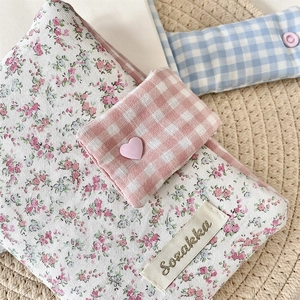 Macro detail of floral fabric journal cover with pink checkered flap and heart button