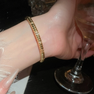 Detail showing 18k gold plated bracelet with textured ridges and sparkling cubic zirconia