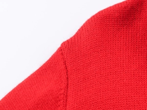 Detailed close-up showing the high-quality knit texture and shoulder seam of the red cardigan