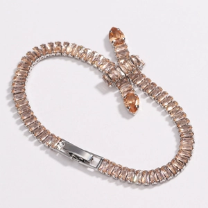 Macro shot of champagne zircon tennis chain with silver-plated knots and folding clasp