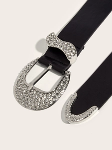 Close-up of vintage black leather belt with sparkling rhinestones on silver buckle