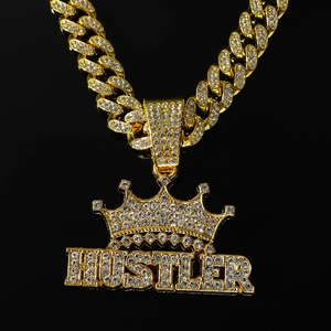 Détail du pendentif couronne Hustler doré serti de cristaux brillants sur chaîne