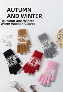 Close-up of winter knit gloves with snowflake pattern in various warm colors and cozy textures