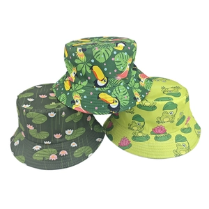 Detail of three printed bucket hats featuring tropical birds, lotus pond, and cartoon frogs