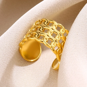 Detail of a golden镂空 wide band ring with anchor chain pattern on beige knit background