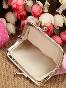 Detail view of pink polka dot coin purse with retro metal clasp and cream fabric lining