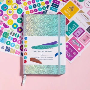 Macro detail of holographic weekly planner with elastic band and colorful stickers