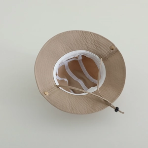 Detail of adjustable windproof rope and white sweatband inside the beige sun hat