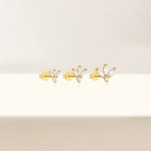 Detail of three golden marquise zircon stud earrings in a gradient size set with crown design