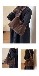 Detail of a large brown suede tote bag with an adjustable leather shoulder strap in use