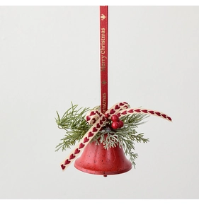 Macro view of vintage red metal Christmas bell ornament with pine needles and ribbons