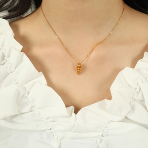 Elegant gold conch shell pendant necklace on female neck with white lace shirt background