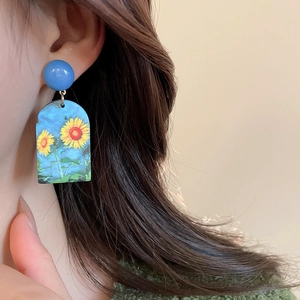 Close-up of artistic acrylic oil painting sunflower drop earrings on model's ear