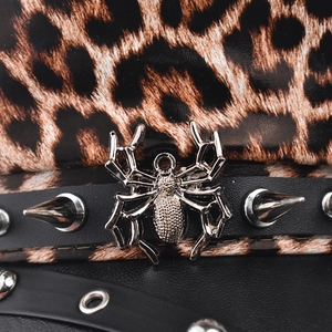 Macro shot of silver spider pendant and metallic spikes on leopard print military cap