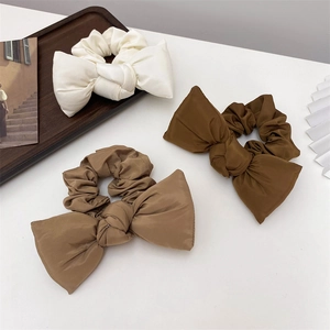 Morandi cotton bow hair scrunchies set in white and brown shades on a desktop