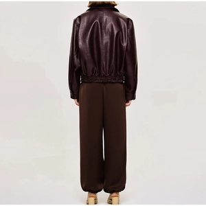 Vue arrière de la veste en similicuir marron foncé et du pantalon à revers assorti
