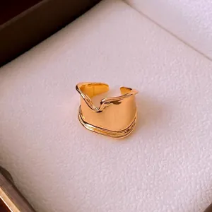 Minimalist wide irregular open ring in golden finish with a polished mirror texture