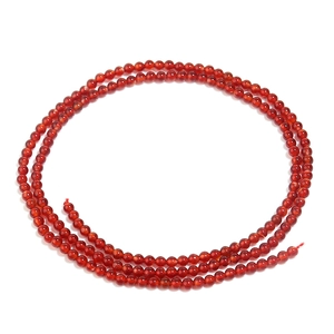 Macro shot of polished red agate round beads for DIY jewelry with smooth glossy texture
