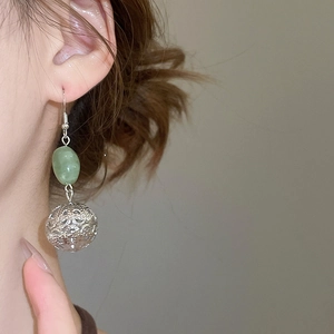 Gros plan de boucles d'oreilles en résine vert émeraude portées pour un look premium