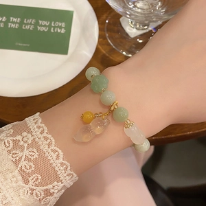 Chinese style beaded bracelet with green jade beads and translucent gourd pendant on wrist