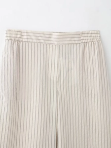 Detail of adjustable elastic waist and stitching on striped casual trousers