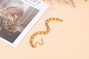 Detail of a double-layered gold bracelet with diverse chain links and an adjustable clasp