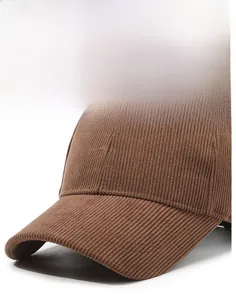 Close-up of dark brown corduroy baseball cap showing fine embroidery and brim texture