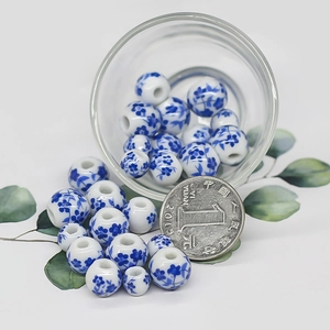 Blue floral porcelain beads for DIY jewelry making shown with a 1 yuan coin for size