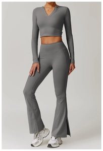 Detail of high-waist flared yoga pants featuring side slits and elastic grey fabric