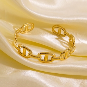 Polished 14K gold-plated stainless steel anchor chain open bangle on silk fabric