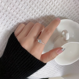 Close-up of heart-shaped moonstone ring with a polished silver band on model hand