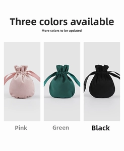 Detail of velvet drawstring jewelry pouches in pink, green, and black luxury fabric